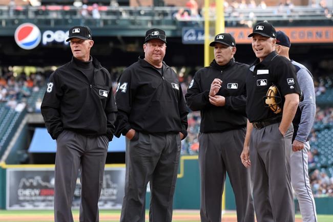 From left to right, umpire Jim Wolf, first base umpire Sam Holbrook, third base umpire Manny Gonzalez and home plate umpire Dan Iassogna wait for batting lineups before a baseball game between the Cleveland Indians and the Detroit Tigers, Friday, June 14, 2019, in Detroit. Wolf was scheduled to be the third base umpire, but left the game in the first inning. (AP Photo/Jose Juarez)