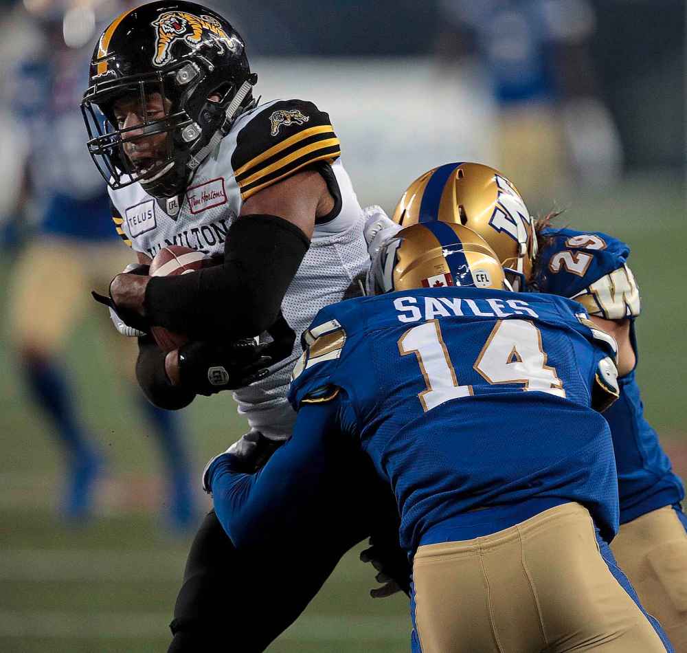 Phil Hossack / Winnipeg Free Press
Hamilton Tiger-Cats' Marcus Tucker carries the ball against the Bombers' Marcus Sayles and Jeff Hecht Friday night at IG Field.