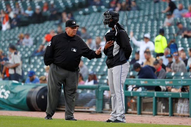 First base umpire D.J. Rayburn tells Miami Marlins pitcher Sandy Alcantara to leave the field before the first pitch of the team's baseball game against the Detroit Tigers in Detroit, Wednesday, May 22, 2019. Alcantara stood with equipment on after national anthem until he was asked to leave the field. (AP Photo/Paul Sancya)