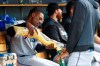 Miami Marlins' Curtis Granderson, left, shares popcorn with a teammate in the dugout during the third inning of the team's baseball game against the Detroit Tigers in Detroit, Tuesday, May 21, 2019. (AP Photo/Paul Sancya)
