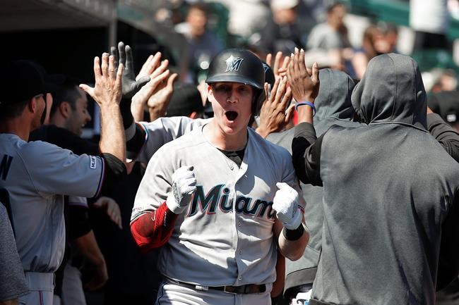 Miami Marlins' Garrett Cooper celebrates in the dugout after hitting grand slam in the ninth inning of a baseball game against the Detroit Tigers in Detroit, Thursday, May 23, 2019. (AP Photo/Paul Sancya)
