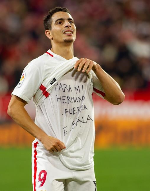 Sevilla's Ben Yedder shows a t-shirt reading 'To my brother, be strong, E. Sala' supporting Cardiff City FC's Argentinian forward Emiliano Sala, as celebrates after scoring during a Spanish Copa del Rey soccer match between Sevilla and FC Barcelona in Seville, Spain, Wednesday Jan. 23, 2019. (AP Photo/Miguel Morenatti)