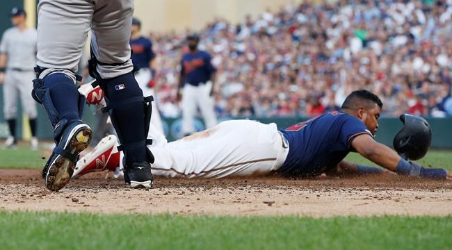 Minnesota Twins' Luis Arraez loses his helmet as he slides by New York Yankees catcher Austin Romine to score on a sacrifice fly by Jake Cave in the second inning of a baseball game Wednesday, July 24, 2019, in Minneapolis. (AP Photo/Jim Mone) 55
