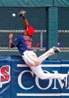 Minnesota Twins' left fielder LaMonte Wade, Jr., who was called up last week, hits the fence as he tries unsuccessfully to catch a fly ball for a home run by Texas Rangers' Elvis Andrus in the sixth inning of a baseball game Saturday, July 6, 2019, in Minneapolis. Wade was injured on the play and left the game. (AP Photo/Jim Mone)