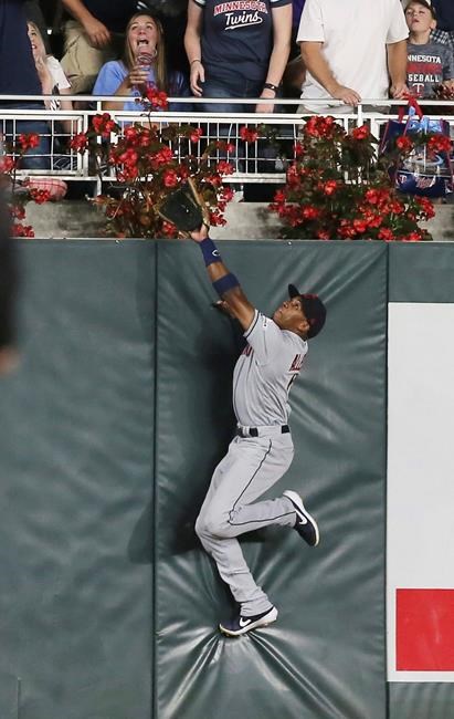 Cleveland Indians left fielder Greg Allen goes up the wall to no avail as Minnesota Twins' Jason Castro hits a solo home run off Indians pitcher Shane Bieber during the fifth inning of a baseball game Friday, Aug. 9, 2019, in Minneapolis. (AP Photo/Jim Mone)