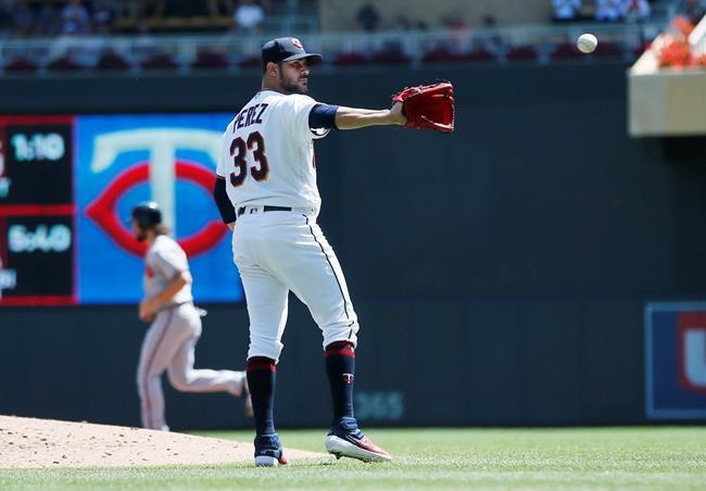 Minnesota Twins pitcher Martin Perez reaches for the ball after giving up a bases-loaded walk to Atlanta Braves' Johan Camargo in the third inning of a baseball game Wednesday, Aug. 7, 2019, in Minneapolis. (AP Photo/Jim Mone)