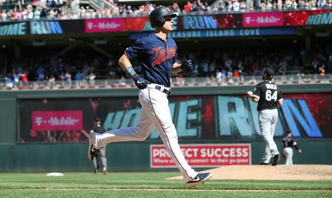 Minnesota Twins' Max Kepler, left, jogs home on his three-run home run off Chicago White Sox pitcher Josh Osich, right, in the seventh inning of a baseball game Sunday, May 26, 2019, in Minneapolis. The Twins won 7-0. (AP Photo/Jim Mone)
