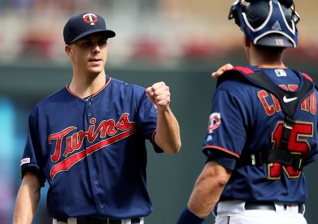 Minnesota Twins relief pitcher Taylor Rogers, left, fist-bumps catcher Jason Castro after their victory over the Kansas City Royals in a baseball game Sunday, Aug. 4, 2019, in Minneapolis. (AP Photo/Jim Mone)