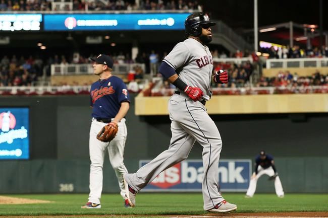 Cleveland Indians' Yasiel Puig, right, jogs home on a wild pitch by Minnesota Twins pitcher Tyler Duffey, left, with a go-ahead run in the sixth inning of a baseball game Saturday, Sept 7, 2019, in Minneapolis. (AP Photo/Jim Mone)
