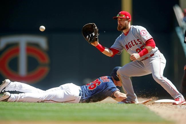 Minnesota Twins' Max Kepler,left, drives safely back to first base as Los Angeles Angels first baseman Jared Walsh, making his major league debut, awaits the ball in a baseball game Wednesday, May 15, 2019, in Minneapolis. (AP Photo/Jim Mone)