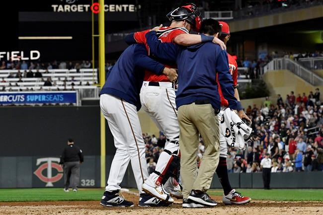 Minnesota Twins' catcher Mitch Garver is helped off the field after he was injured tagging out Los Angeles Angels' Shohei Ohtani as he attempted to score from second base on a hit by Brian Goodwin in the eighth inning of a baseball game Tuesday, May 14, 2019, in Minneapolis. The Twins won 4-3. (AP Photo/Jim Mone)
