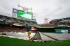 Members of the grounds crew remov the tarp from the infield during a rain delay Friday, July 5, 2019, before a baseball game between the Texas Rangers and the Twins in Minneapolis. (Anthony Souffle/Star Tribune via AP)