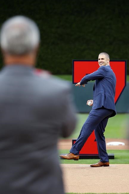 Former Minnesota Twins player Joe Mauer, right, throws the opening pitch to his father Jake Mauer after his No. 7 was retired prior to the baseball game against the Kansas City Royals, Saturday, June 15, 2019, in Minneapolis. (AP Photo/Stacy Bengs)