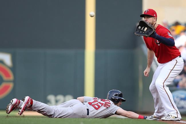 Boston Red Sox's Andrew Benintendi slides safely back to first base against as Minnesota Twins' C.J. Cron catches the ball from Michael Pineda during the first inning of a baseball game Tuesday, June 18, 2019, in Minneapolis. (AP Photo/Stacy Bengs)