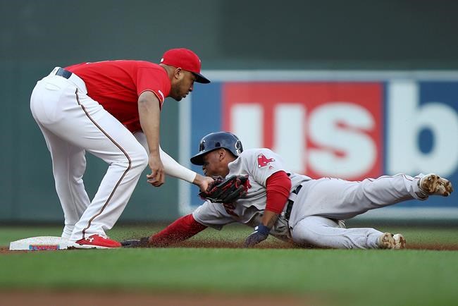 Boston Red Sox's Rafael Devers gets tagged by Minnesota Twins' Jonathan Schoop for an out after trying to steal to second base during the fourth inning of a baseball game Tuesday, June 18, 2019, in Minneapolis. Schoop caught the ball from catcher Mitch Garver. (AP Photo/Stacy Bengs)