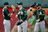 Oakland Athletics outfielders Seth Brown, left, Mark Canha, center, and Robbie Grossman celebrate after a baseball game against the Kansas City Royals, Thursday, Aug. 29, 2019, in Kansas City, Mo. (AP Photo/Charlie Riedel)