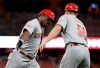Cincinnati Reds' Yasiel Puig is congratulated by third base coach J.R. House (56) after hitting a solo home run during the fifth inning of a baseball game against the St. Louis Cardinals on Tuesday, June 4, 2019, in St. Louis. (AP Photo/Jeff Roberson)