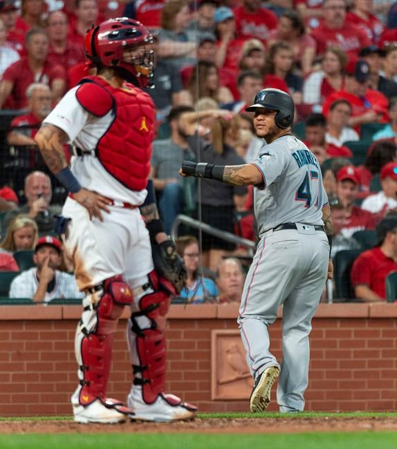 Miami Marlins' Harold Ramirez, right, looks back at St. Louis Cardinals catcher Yadier Molina, left, after Ramirez scored during the sixth inning of a baseball game Thursday, June 20, 2019, in St. Louis. (AP Photo/L.G. Patterson)