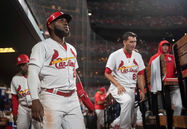St. Louis Cardinals' Marcell Ozuna, front left, celebrates in the dugout after scoring during the seventh inning of a baseball game against the Los Angeles Angels, Friday, June 21, 2019, in St. Louis. (AP Photo/L.G. Patterson)