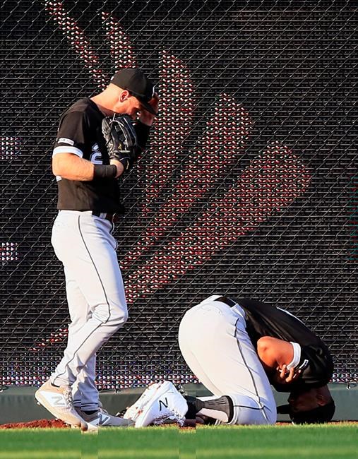 Chicago White Sox center fielder Charlie Tilson, left, looks to help left fielder Eloy Jimenez, after the pair collided catching a fly ball hit by Kansas City Royals' Whit Merrifield during the first inning of a baseball game at Kauffman Stadium in Kansas City, Mo., Tuesday, July 16, 2019. Jimenez was injured on the play. (AP Photo/Orlin Wagner)