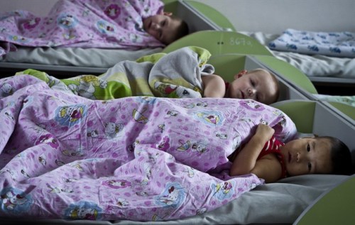 Kyrgyz orphans are in bed in an orphanage in Bishkek, Kyrgyzstan, Thursday, Jan. 31, 2013. Americans were in process of adopting 65 orphans from Kyrgyzstan when it suspended international adoptions in 2008 due to allegations of fraud. Some of the Americans gave up, some of the children were placed in domestic adoptions, and last summer nine of the remaining children finally were allowed to go to America. There are now 16 U.S. families still waiting, five year later. (AP Photo/Abylay Saralayev)