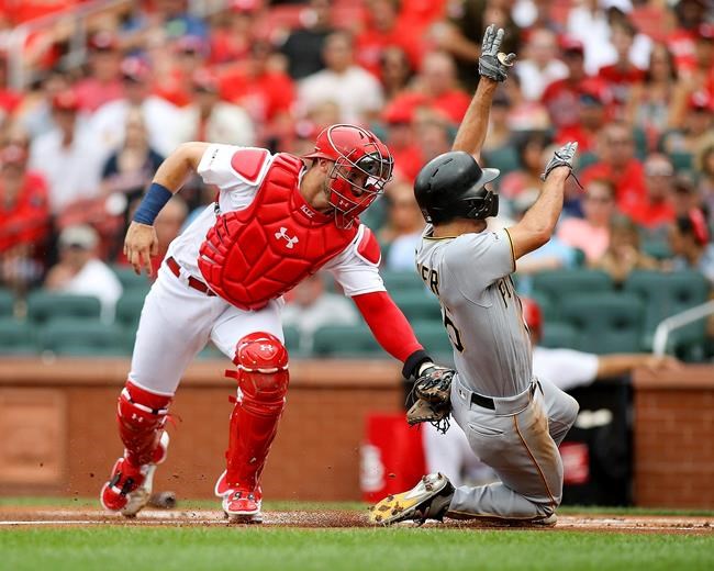 St. Louis Cardinals catcher Andrew Knizner, left, tags out Pittsburgh Pirates' Adam Frazier, right, during the first inning of a baseball game Sunday, Aug. 11, 2019, in St. Louis. (AP Photo/Scott Kane)