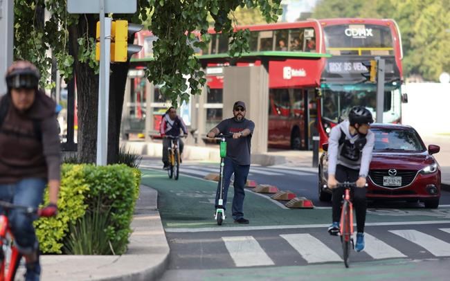 A man rides an electric rental scooter on Reforma Avenue in Mexico City, Thursday, Aug. 1, 2019. An electric scooter firm has temporarily ceased operations in Mexico City because so many of its two-wheeled units have been stolen. The Grin company said in a statement that
