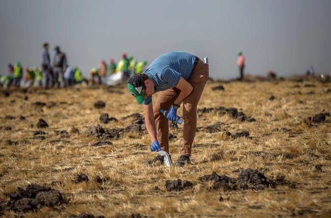 A foreign investigator examines wreckage at the scene where the Ethiopian Airlines Boeing 737 Max 8 crashed shortly after takeoff on Sunday killing all 157 on board, near Bishoftu, or Debre Zeit, south of Addis Ababa, in Ethiopia Tuesday, March 12, 2019. Ethiopian Airlines had issued no new updates on the crash as of late afternoon Tuesday as families around the world waited for answers, while a global team of investigators began picking through the rural crash site. (AP Photo/Mulugeta Ayene)
