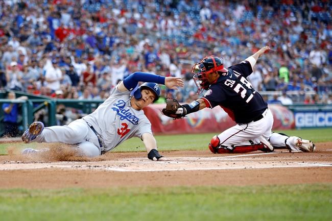 Los Angeles Dodgers' Joc Pederson, left, slides past Washington Nationals catcher Kurt Suzuki for a run on Cody Bellinger's single in the first inning of a baseball game, Friday, July 26, 2019, in Washington. (AP Photo/Patrick Semansky)