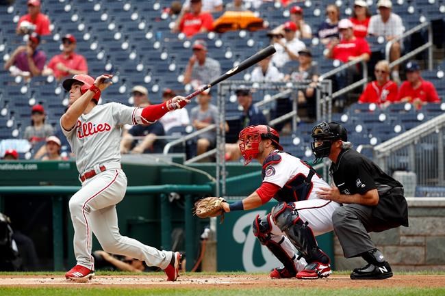 Philadelphia Phillies' Scott Kingery watches his solo home run in front of Washington Nationals catcher Yan Gomes and umpire Paul Nauert in the first inning of the first baseball game of a doubleheader, Wednesday, June 19, 2019, in Washington. (AP Photo/Patrick Semansky)