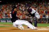 Washington Nationals' Kurt Suzuki, left, slides past Cleveland Indians catcher Roberto Perez for a run on Gerardo Parra's double in the second inning of a baseball game, Friday, Sept. 27, 2019, in Washington. (AP Photo/Patrick Semansky)