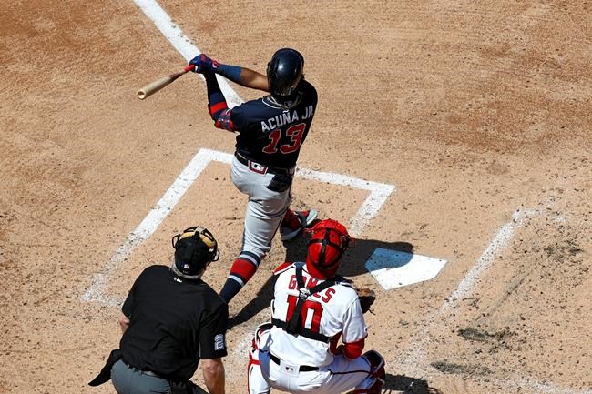 Atlanta Braves' Ronald Acuna Jr. watches his solo home run in front of Washington Nationals catcher Yan Gomes and umpire Bill Miller in the sixth inning of a baseball game, Sunday, June 23, 2019, in Washington. (AP Photo/Patrick Semansky)