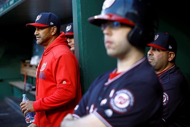 Washington Nationals manager Dave Martinez, left, watches the first inning of the team's baseball game against the New York Mets, Tuesday, May 14, 2019, in Washington. (AP Photo/Patrick Semansky)