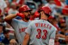 Cincinnati Reds' Jesse Winker (33) celebrates his solo home run with Joey Votto during the first inning of a baseball game against the Washington Nationals at Nationals Park, Monday, Aug. 12, 2019, in Washington. (AP Photo/Alex Brandon)