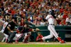 Atlanta Braves' Nick Markakis hits a sacrifice fly ball in front of Washington Nationals catcher Yan Gomes and umpire Rob Drake in the fifth inning of a baseball game against the Washington Nationals, Friday, Sept. 13, 2019, in Washington. Ronald Acuña Jr. scored on the play. (AP Photo/Patrick Semansky)