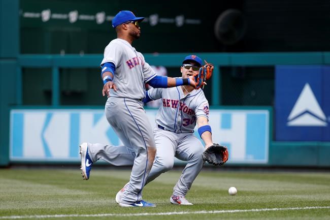 New York Mets right fielder Michael Conforto, right, collides with second baseman Robinson Cano as they fail to catch a fly ball that was hit by Washington Nationals' Howie Kendrick in the fifth inning of a baseball game, Thursday, May 16, 2019, in Washington. Conforto left the game after the play. (AP Photo/Patrick Semansky)