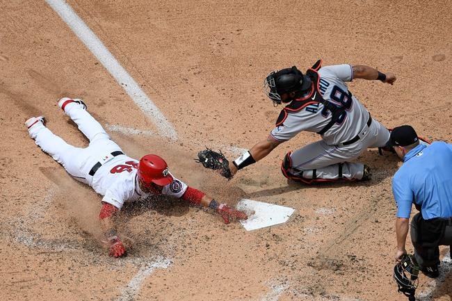 Washington Nationals' Gerardo Parra, left, slides home to score against Miami Marlins catcher Jorge Alfaro (38) on a single by Max Scherzer during the fifth inning of a baseball game, Monday, May 27, 2019, in Washington. (AP Photo/Nick Wass)