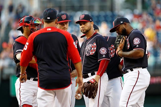 Washington Nationals starting pitcher Anibal Sanchez, center, gathers on the mound with teammates and pitching coach Paul Menhart, second from left, after walking Los Angeles Dodgers' Max Muncy to load the bases in the first inning of a baseball game, Friday, July 26, 2019, in Washington. (AP Photo/Patrick Semansky)