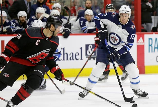 Winnipeg Jets' Kevin Hayes (12) looks to shoot while Carolina Hurricanes' Justin Williams defends during the second period of an NHL hockey game in Raleigh, N.C., Friday, March 8, 2019. (AP Photo/Gerry Broome)