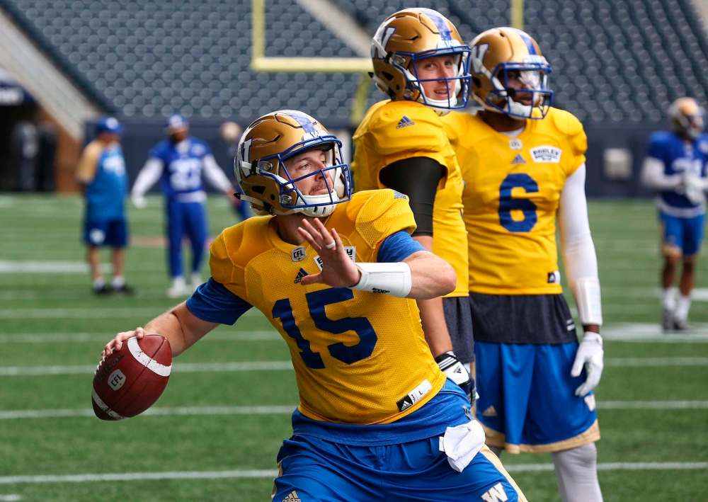 MIKE DEAL / WINNIPEG FREE PRESS
Winnipeg Blue Bombers quarterbacks Drew Willy (5) and Dominique Davis (6) watch new starting QB Matt Nichols (15) throw the ball during practice at Investors Group Field Sunday.