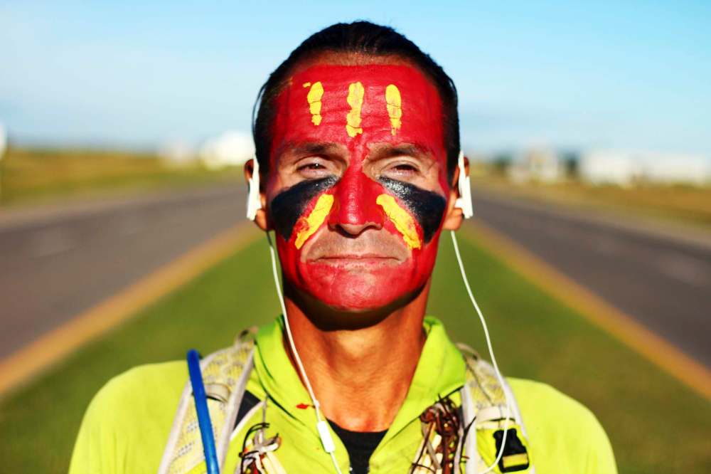 TOM BATEMAN / THE BRANDON SUN
Brandon Sun Gwich'in runner Brad Firth, better known by the moniker Caribou Legs, is photographed along the Trans-Canada Highway near Brandon on Wednesday, July 27, 2016. Firth is running across Canada in traditional regalia that includes warpaint, feathers, a chest plate and hand drum to bring attention to the Inquiry into Missing and Murdered Aboriginal Women and to promote a culture of consent amongst youth.