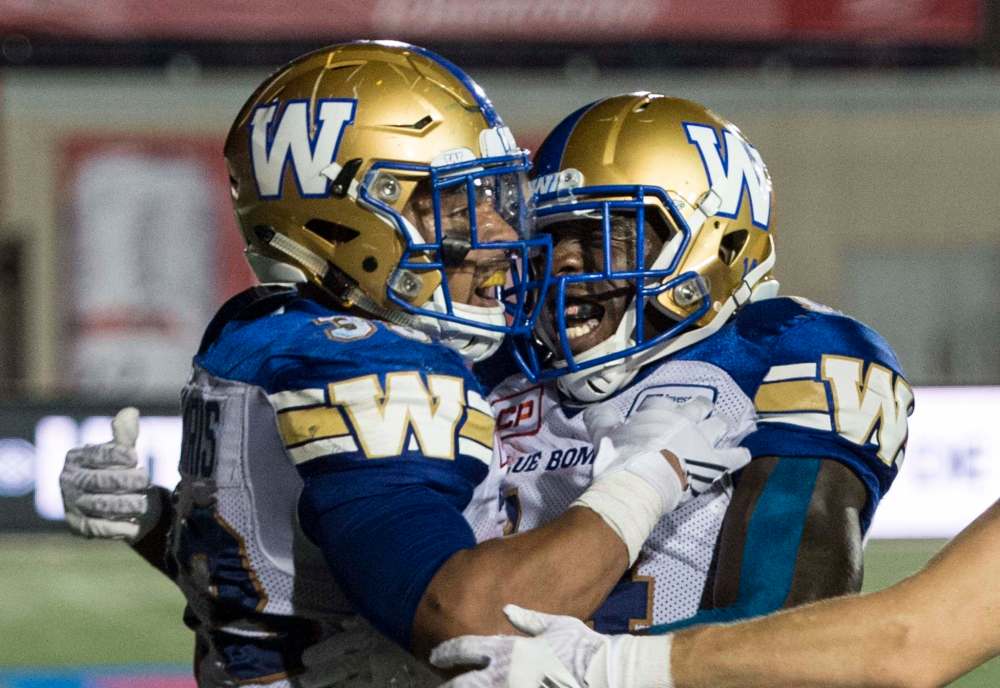 Bombers running back Andrew Harris (left) celebrates his fourth-quarter touchdown against the Alouettes with teammate Quincy McDuffie.