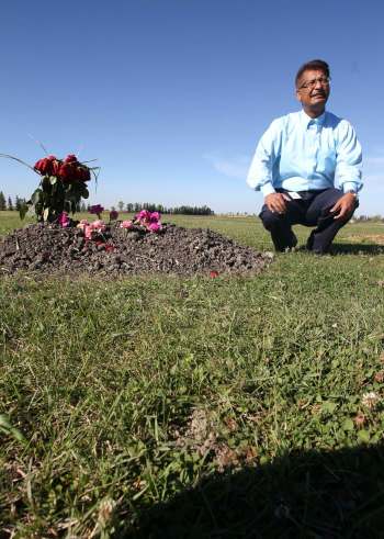 JOE BRYKSA / WINNIPEG FREE PRESS
Abdul Aziz kneels in the Muslim section of the Transcona cemetery.