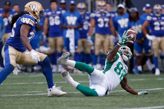 JOHN WOODS / THE CANADIAN PRESSSaskatchewan Roughriders' Naaman Roosevelt (82) hauls in the pass in front of Winnipeg Blue Bombers' Tony Burnett (26) during first half CFL Banjo Bowl action.
