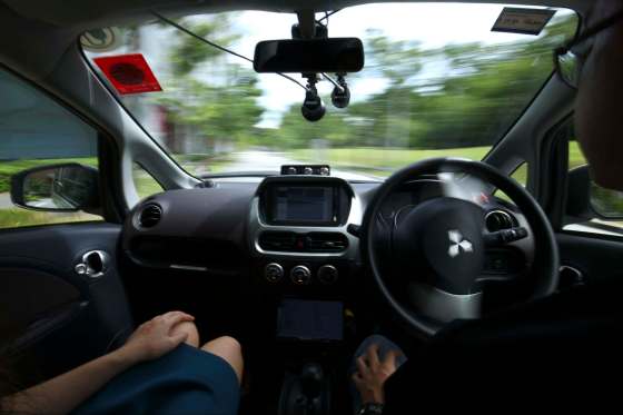 YONG TECK LIM / THE ASSOCIATED PRESSA driver, right, gets his hands off of the steering wheel of an autonomous vehicle during its test drive in Singapore. The city will look to other municipalities to see how the technology will disrupt planning.