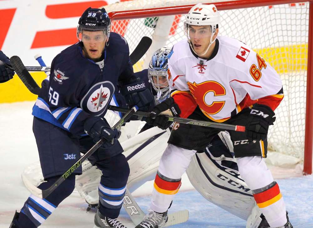 BORIS MINKEVICH / WINNIPEG FREE PRESS
Winnipeg Jets defenceman Brendan Kichton and Calgary Flames winger Garnet Hathaway duel in front of Jets goalie Eric Comrie Tuesday night at the MTS Centre.