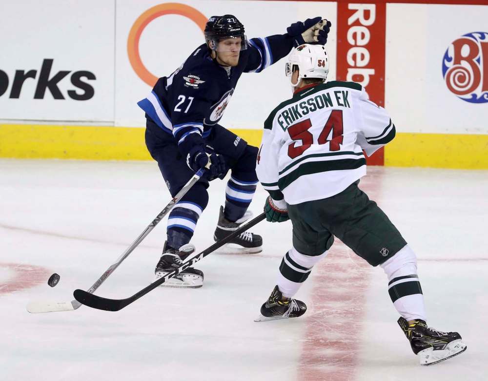 Trevor Hagan / The Canadian Press
Winnipeg Jets Nikolaj Ehlers loses the puck and tries to dodge a hit by Minnesota Wild's Joel Eriksson Ek during pre-season NHL hockey at the MTS Centre Thursday.