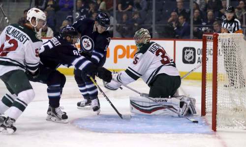 Trevor Hagan / The Canadian Press
Jets centre Mathieu Perreault knocks the puck past Minnesota Wild goaltender Darcy Kuemper during second-period pre-season NHL action Thursday in Winnipeg..