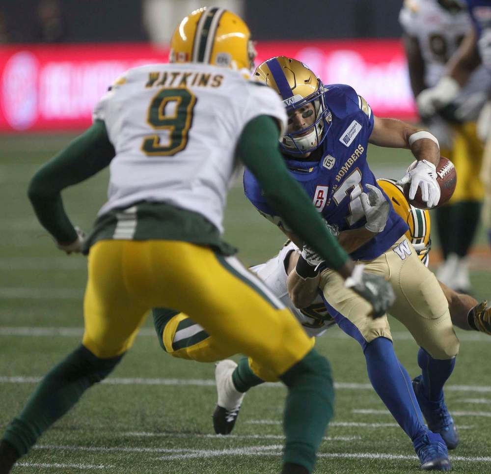 JOE BRYKSA / WINNIPEG FREE PRESS
Edmonton Eskimos JC Sherritt and his teammate Patrick Watkins, front, strip the ball from Winnipeg Blue Bomber Weston Dressler during his touchdown attempt in the second quarter.