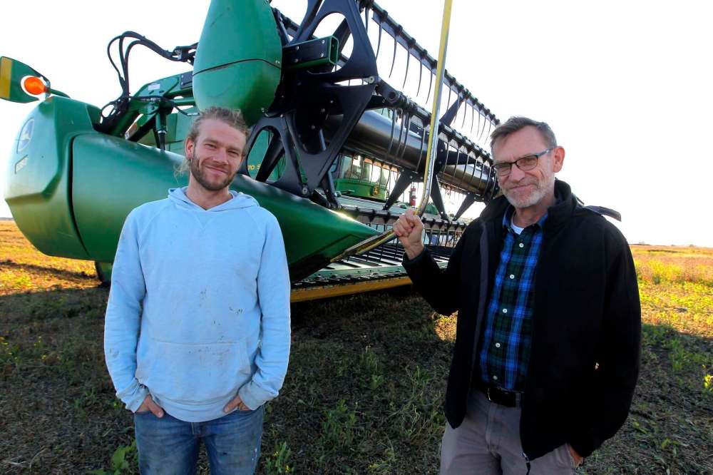 BORIS MINKEVICH / WINNIPEG FREE PRESS
Royden Loewen (right) the chairman of Mennonite studies at the University of Winnipeg — and part-time farmer — takes a break from harvesting soybeans with his son Sasha. Royden is researching how Mennonites around the world have faced the challenge of maintaining their farms and their faith.